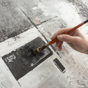 Künstlerhand beim Malen auf strukturierter Leinwand